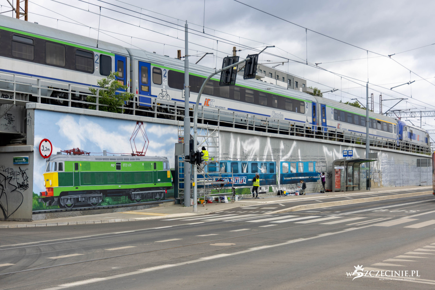 Mural z kibicami Pogoni jadącymi na mecz powstaje tuż obok prawdziwych pociągów [foto]